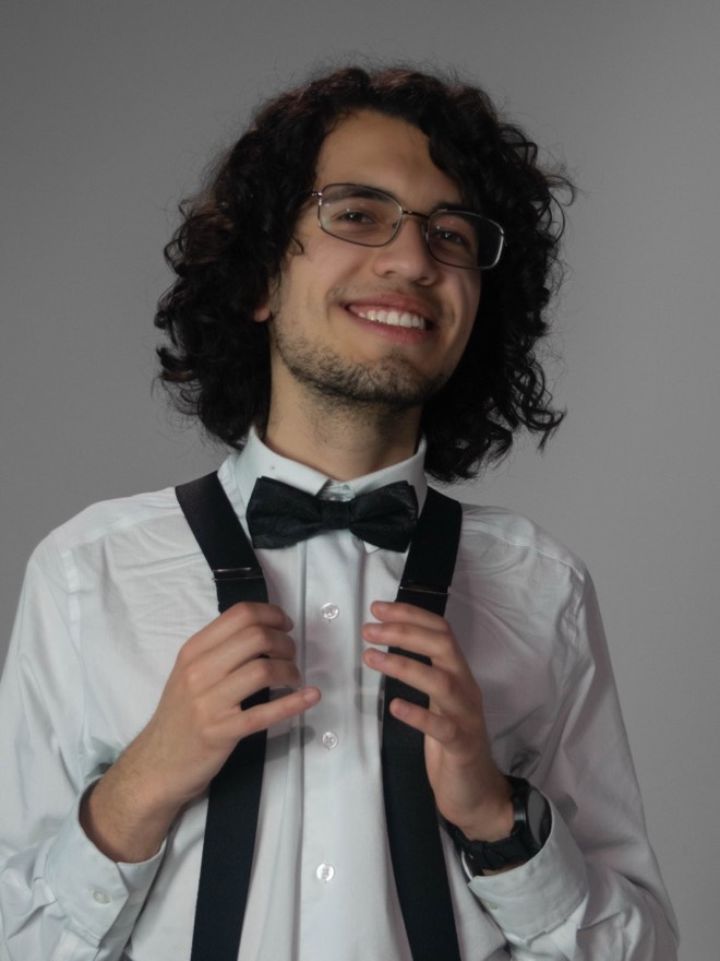 Victor smiling, hands on his suspenders